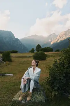 Молодая женщина в плед на фоне горных вершин