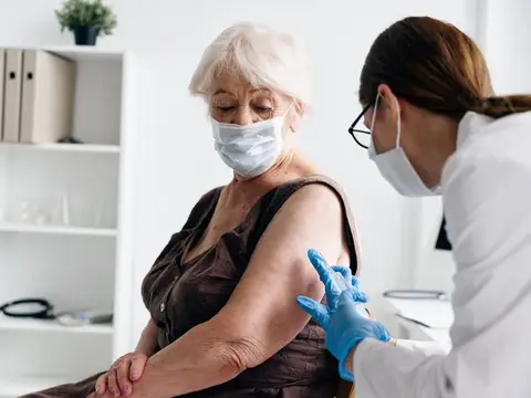 Медсестра делает пациенту укол в плечо, вакцинация от COVID-19, паспорт вакцинации