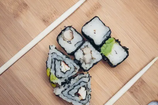Роллы с начинкой и палочки на бамбуковой доске