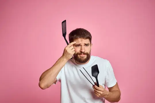 Грустный мужчина с кухонными инструментами в руках: половник и совок, эмоции