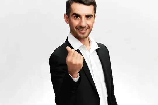 Белый мужчина в деловом костюме с улыбкой показывает жест, обозначающий деньги, банковский работник, профессиональный вид на изолированном фоне