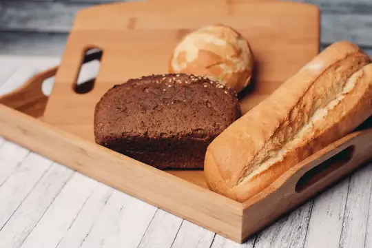 Свежий хлеб и булочки на деревянной доске