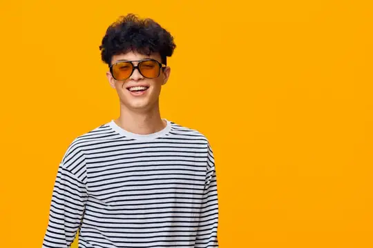 Улыбающийся парень в солнечных очках на жёлтом фоне