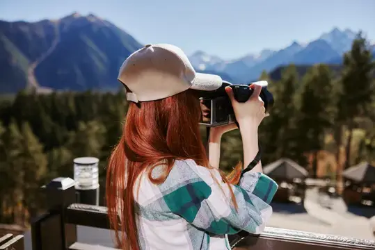Молодая женщина фотографирует горы