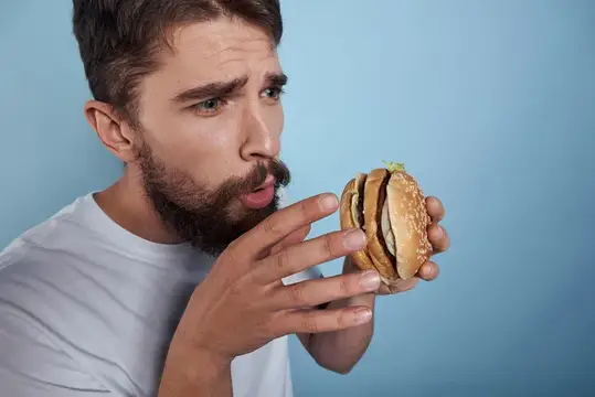 Эмоциональный мужчина с гамбургером