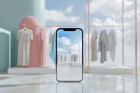 iPhone на столе перед стойкой с одеждой на фоне голубого неба