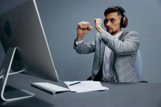 Менеджер работает за компьютером в наушниках в офисе