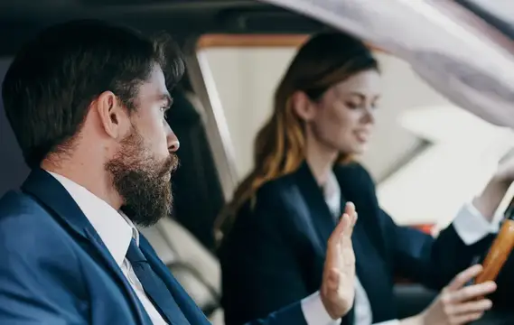 Деловой мужчина и женщина сидят в салоне автомобиля, общение, эмоции