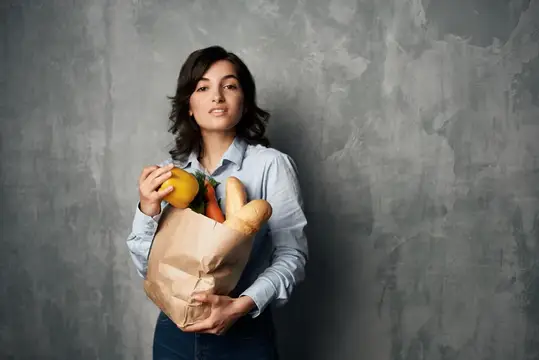 Женщина с пакетом продуктов в супермаркете