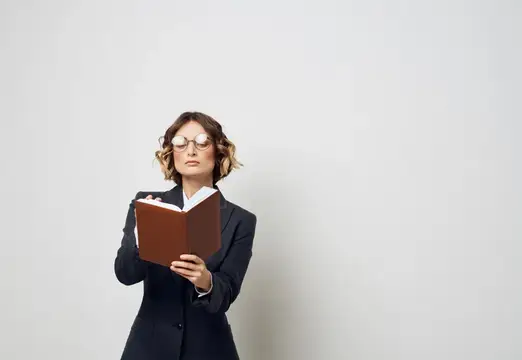 Женщина в костюме с блокнотом в руках на светлом фоне, работа, модель