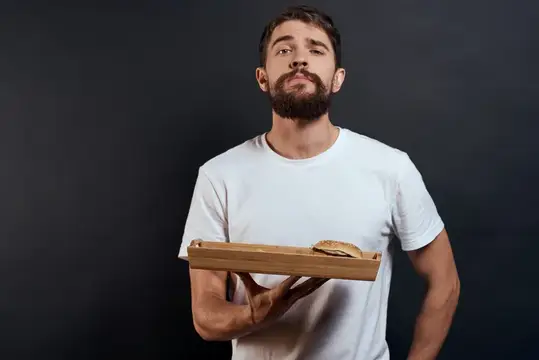 Мужчина и женщина с подносом, на котором лежат картошка фри и гамбургер, еда из ресторана быстрого питания