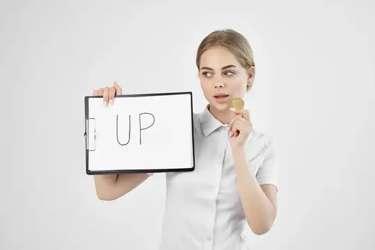 Деловая женщина держит в руках бумагу с надписью «Bitcoin» и символом криптовалюты