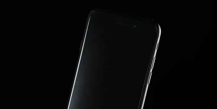 Смартфон с черным экраном на темном фоне