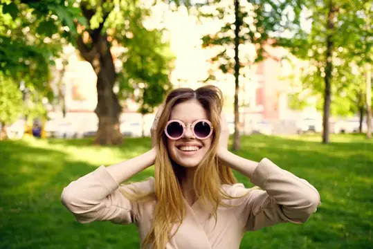 Женщина в солнцезащитных очках на прогулке в парке, свежий воздух, здоровый образ жизни