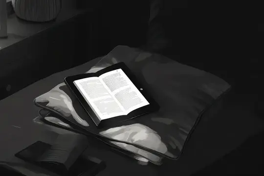 Планшет с открытой книгой лежит на подушке в тёмной спальне