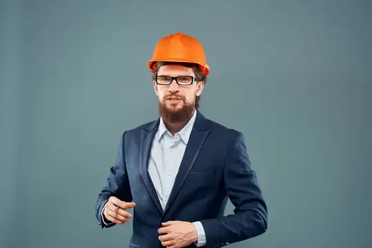 Эмоциональный мужчина, работающий в строительной отрасли, на изолированном фоне символизирует успех