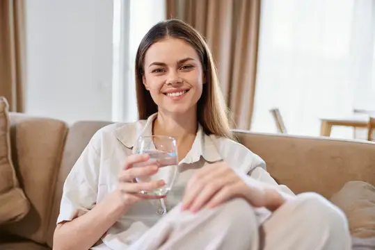 Женщина улыбается, стакан, вода, диван, дом, расслабленный портрет