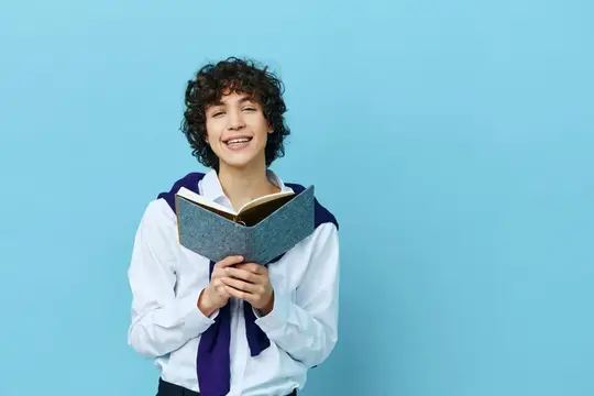 Улыбающийся кудрявый парень с книгой на голубом фоне