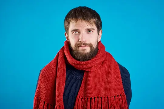 Бородатый мужчина в красном шарфе на синем фоне