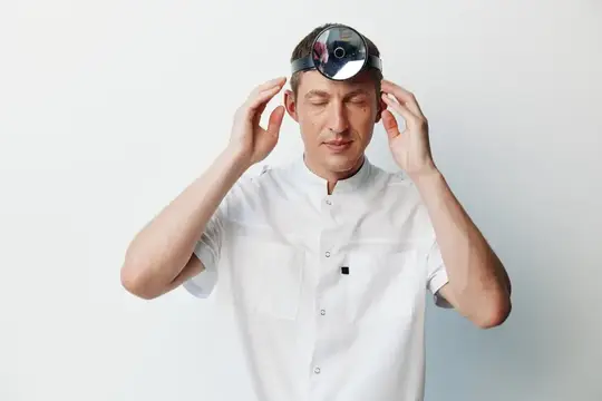 Зрелый мужчина, лысеющий, в шляпе и рубашке, стоит и выражает удивление, замешательство и эмоциональное потрясение