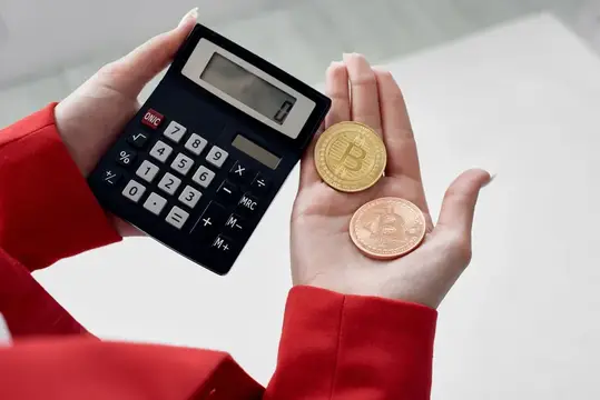 Женские руки с калькулятором и монетами биткоин на ладони