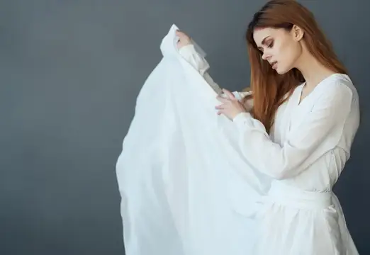 Красивая женщина в белом платье на тёмном фоне, модель