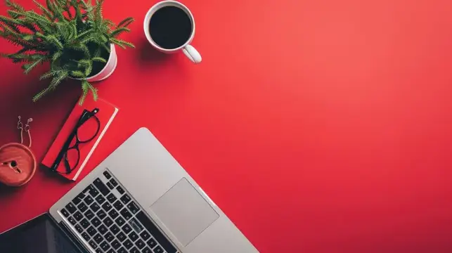 Рабочий стол с ноутбуком, кофе и блокнотом на красном фоне