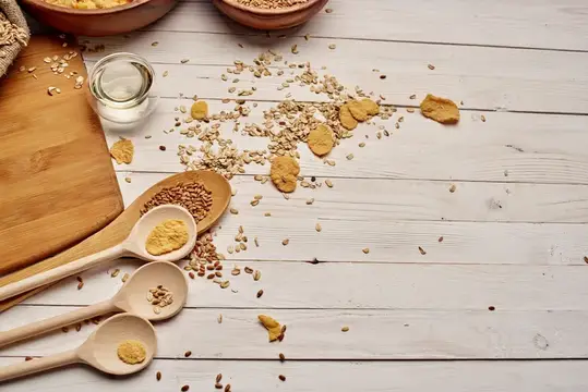 Деревянные ложки с крупами и зёрнами на светлом столе