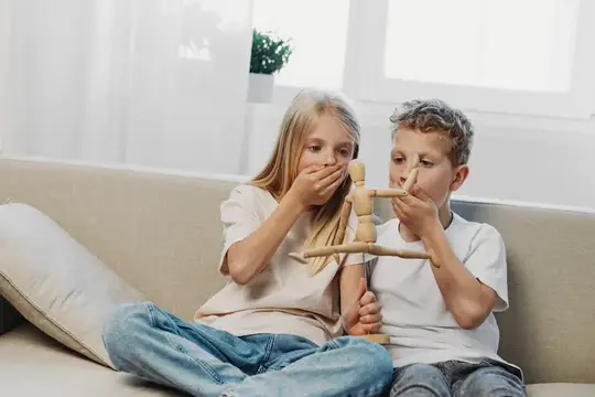 Мальчик и девочка играют с деревянной игрушкой на диване