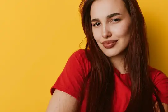 Молодая шатенка в красной футболке на жёлтом фоне