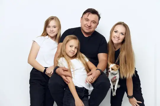 Светловолосая семья с двумя дочерьми и чихуахуа на белом фоне