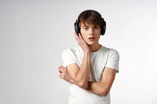 Парень в белой футболке с наушниками, музыка, технологии, светлый фон