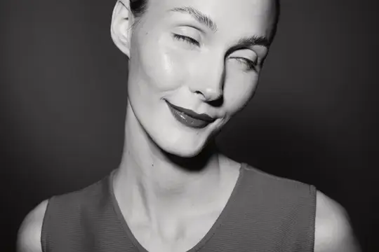 Черно-белый портрет улыбающейся женщины с прикрытыми глазами