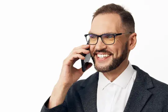 Улыбающийся мужчина в очках говорит по телефону