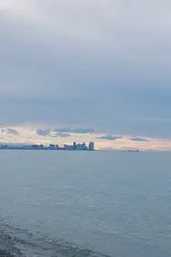 Спокойная гладь воды и силуэт города в пасмурный день