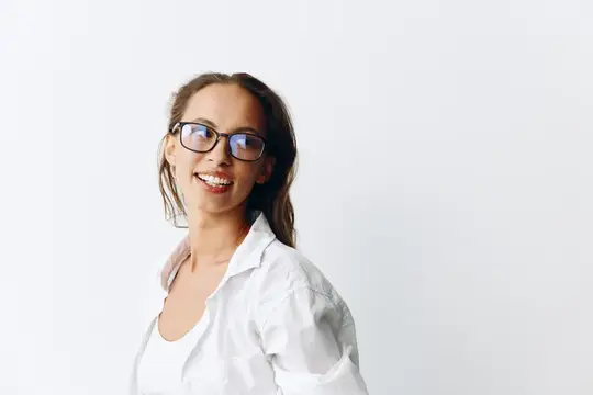 Улыбающаяся девушка в очках и белой рубашке на светлом фоне