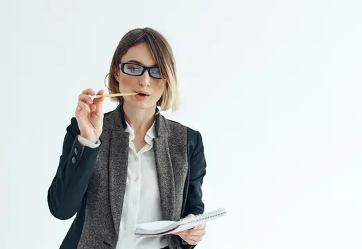 Деловая женщина в классическом костюме и очках работает в сфере финансов