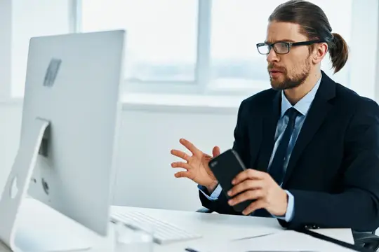 Мужчина в костюме работает перед компьютером с документами, стиль жизни