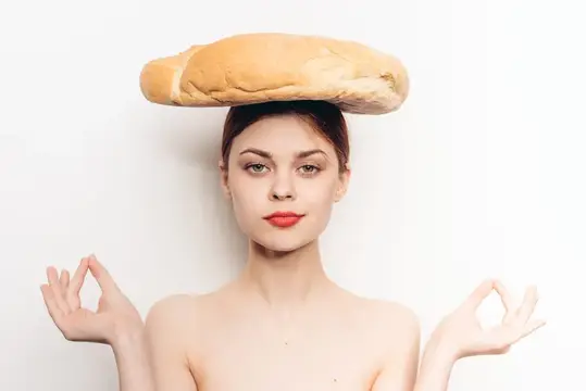 Счастливая женщина с батоном на голове, жестикулирующая руками, медитация и макияж, модель