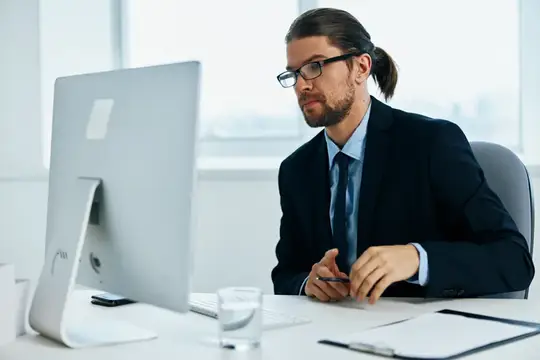 Мужчина в костюме, официальное лицо, работает за компьютером