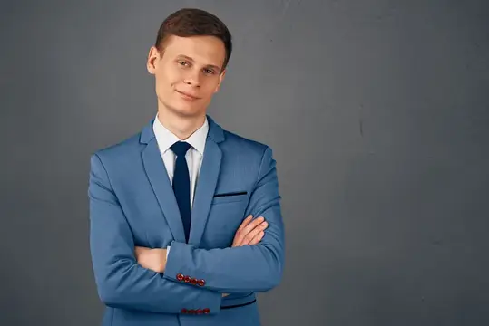 Уверенный в себе бизнесмен в костюме позирует на изолированном фоне