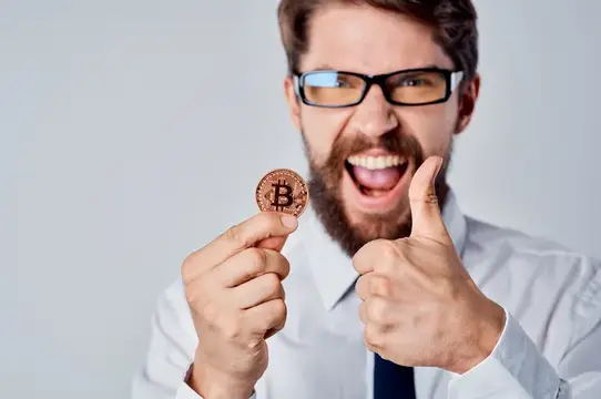 Весёлый мужчина с золотой монетой Bitcoin, криптовалюта, финансы
