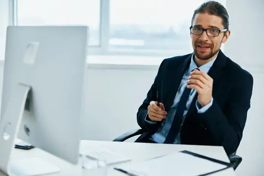 Офисный работник в очках за рабочим столом, работа с технологиями