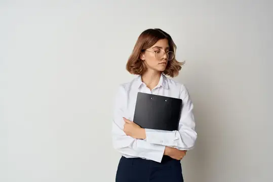 Жизнерадостная женщина-менеджер в белой рубашке работает с документами профессионально