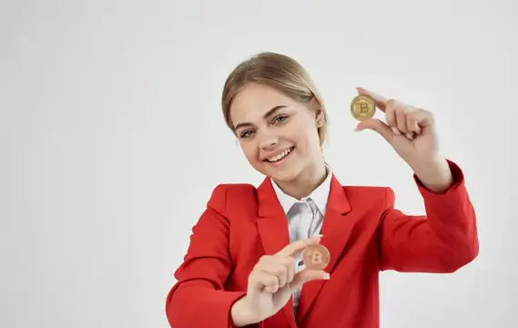 Жизнерадостная деловая женщина в красном пиджаке с криптовалютой Bitcoin и электронными деньгами