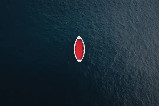 Потрясающий вид сверху на красную лодку на тёмно-синей воде, идеально подходит для иллюстрации тем отдыха, путешествий, приключений и освежающего побега