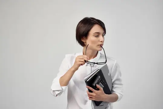 Деловая женщина в очках, излучающая уверенность в себе, на светлом фоне
