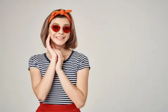 Улыбающаяся девушка в красных очках и полосатой футболке