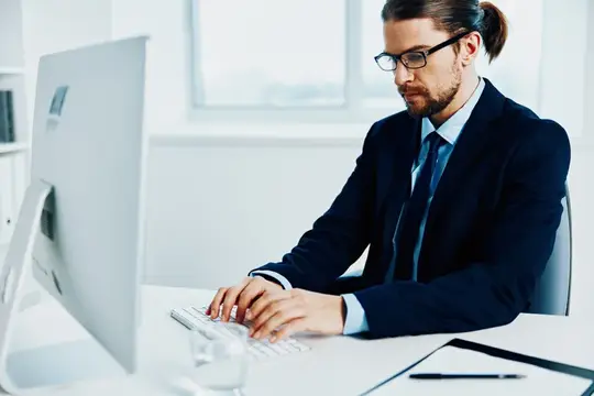 Мужчина-менеджер в очках работает с документами за письменным столом