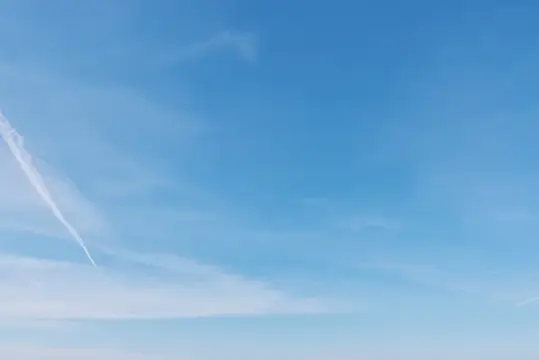 Ясное голубое небо с тонким следом самолёта